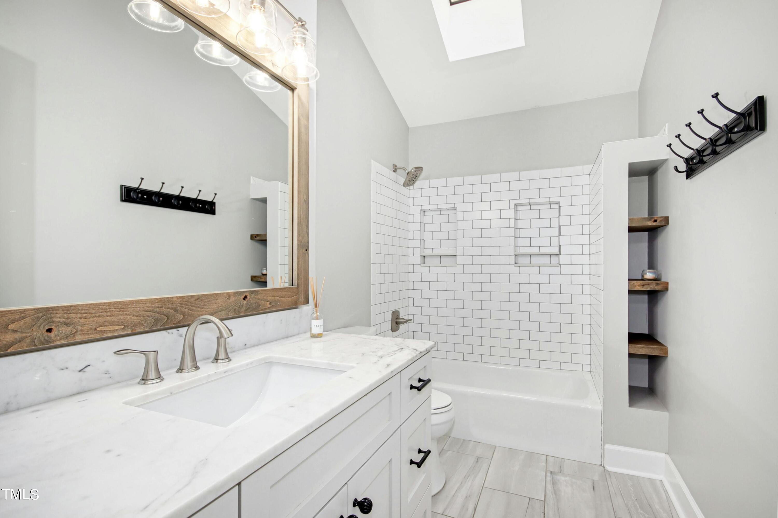 8605 Yucca Trail Raleigh, NC 27615 - Photo 28 of 42 a bathroom with a granite countertop sink a toilet a bathtub and shower
