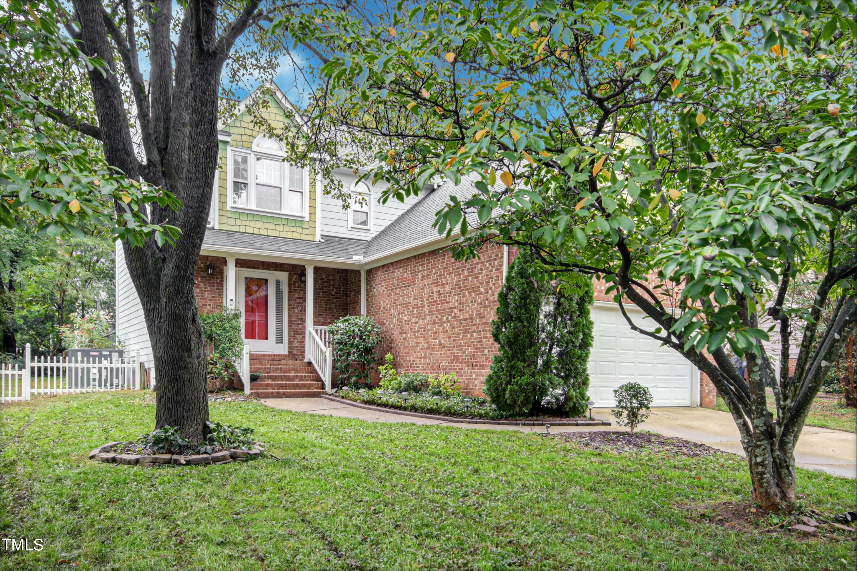 8605 Yucca Trail Raleigh, NC 27615 - Photo 42 of 42 a front view of a house with a yard and a large tree