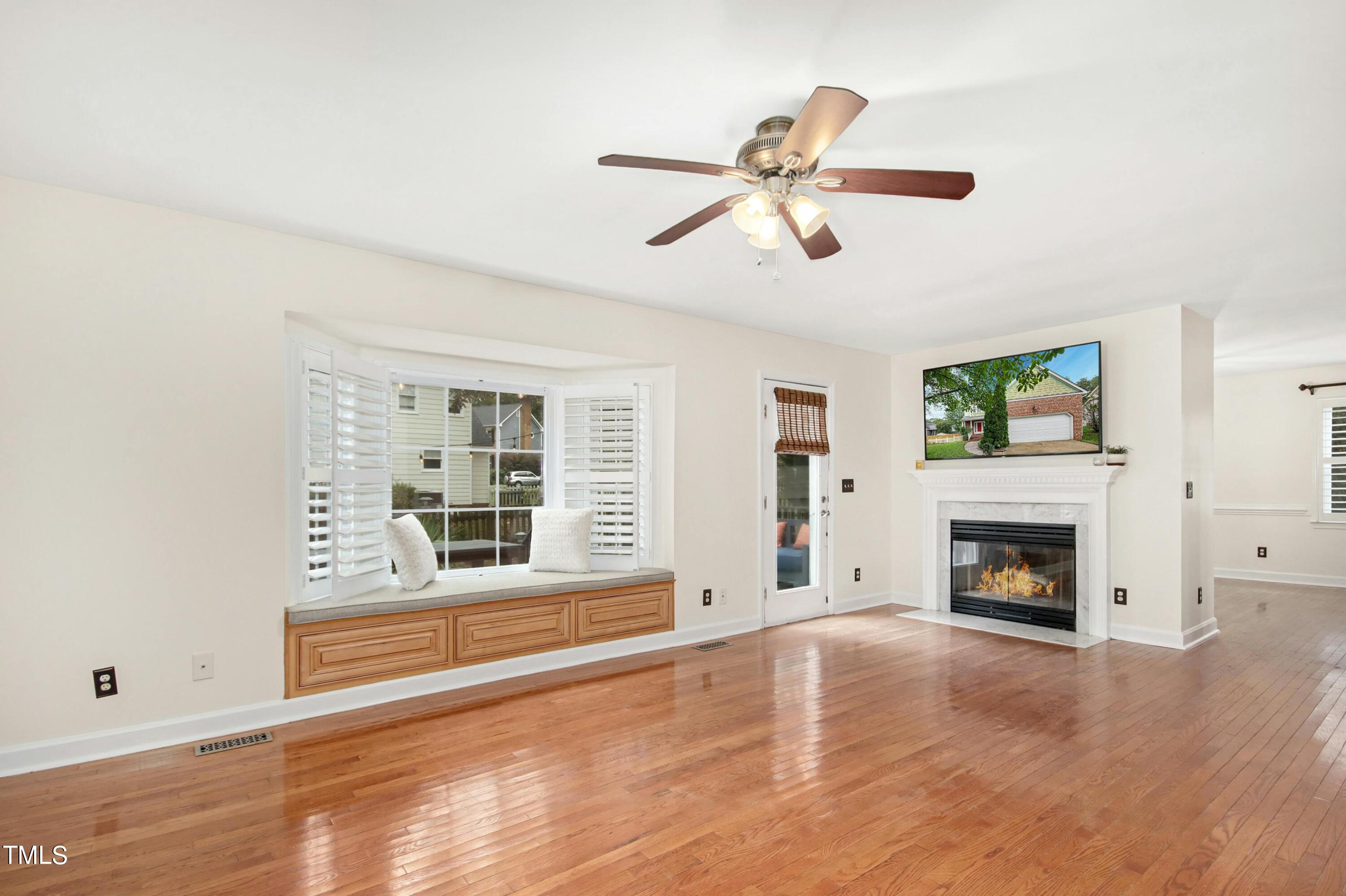 8605 Yucca Trail Raleigh, NC 27615 - Photo 6 of 42 a view of an empty room with wooden floor fireplace and a window