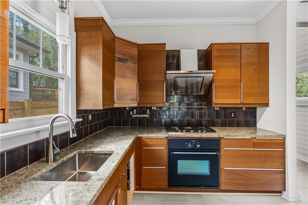 1440 Everhart Street Southwest Atlanta, GA 30310 - Photo 11 of 27 a kitchen with stainless steel appliances granite countertop a stove and a sink