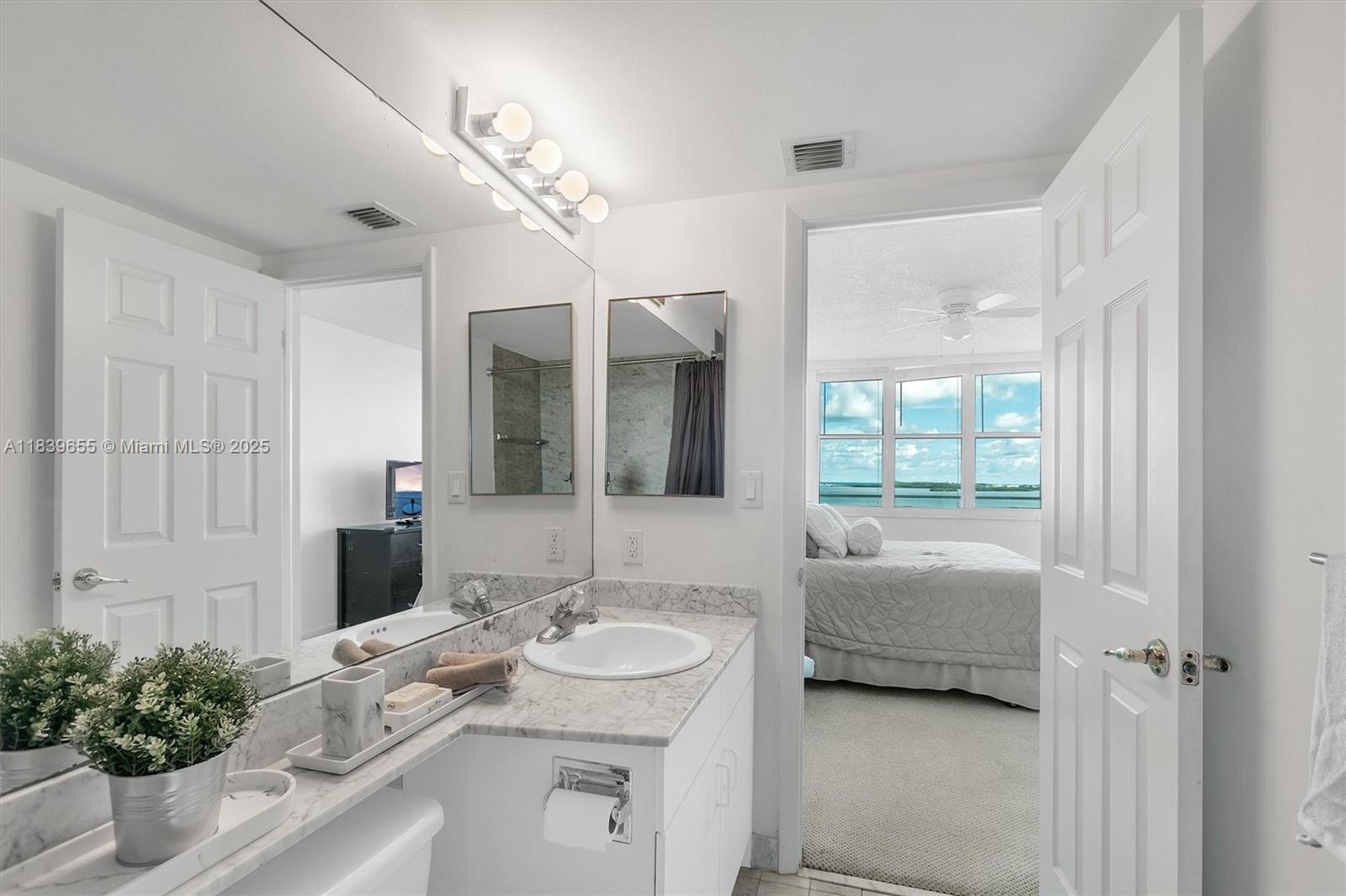 Brickell Miami, FL 33131 - Photo 20 of 32 a en suite bathroom with a granite countertop sink and a mirror