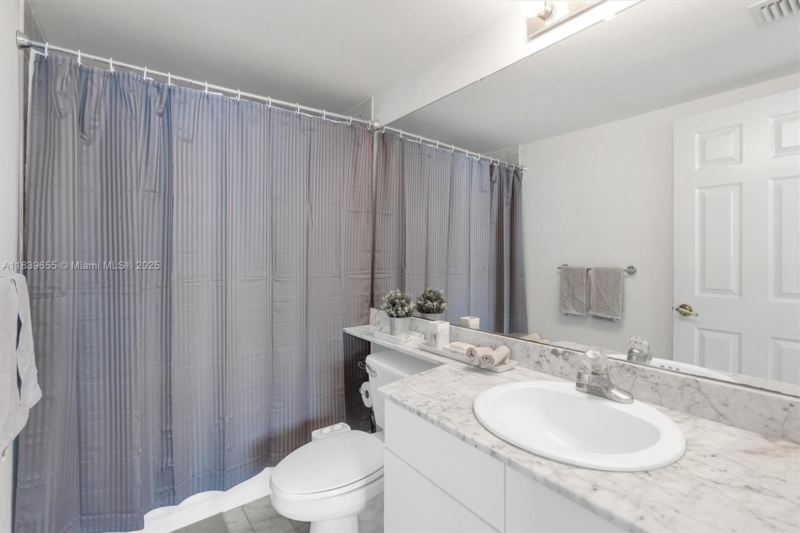 Brickell Miami, FL 33131 - Photo 21 of 32 a bathroom with a toilet a sink and a mirror