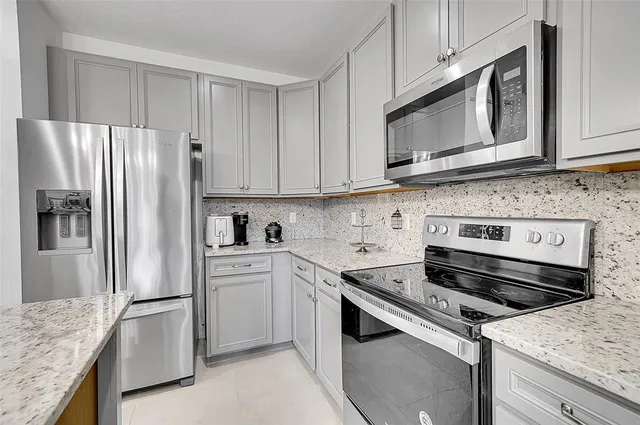 a kitchen with granite countertop cabinets stainless steel appliances and a counter space