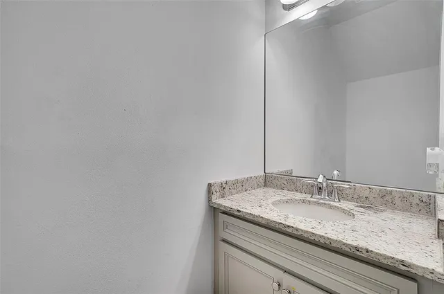 a bathroom with a granite countertop sink and vanity