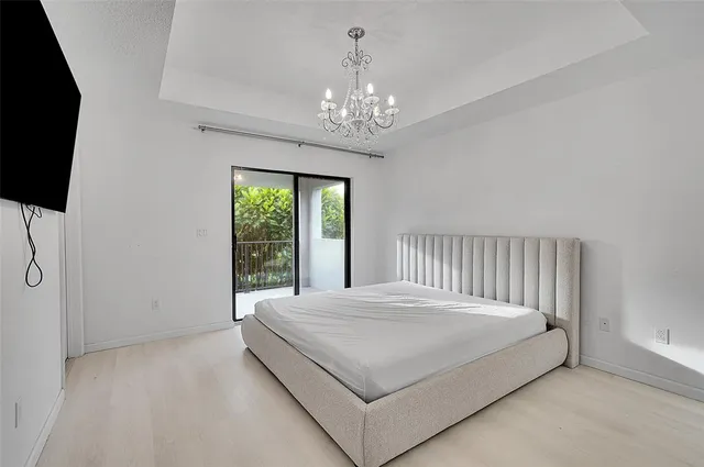 a bed sitting in a spacious bedroom next to a window