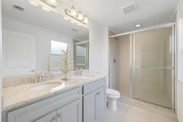 a bathroom with a granite countertop sink a toilet and shower