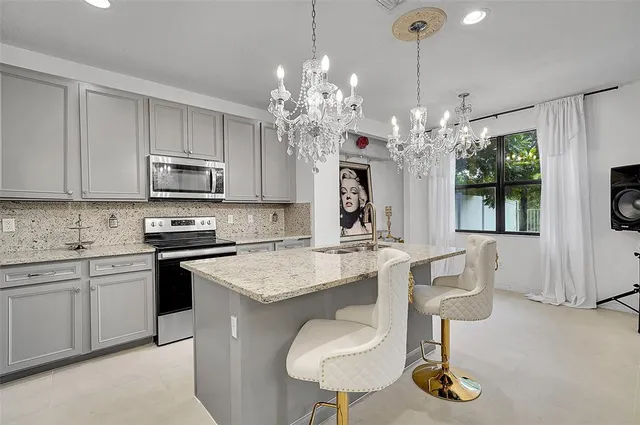 a kitchen with kitchen island granite countertop a sink cabinets and window