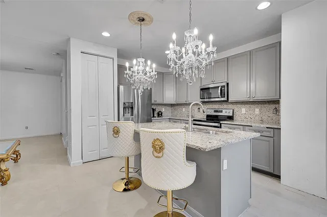 a kitchen with kitchen island granite countertop stainless steel appliances a sink stove and refrigerator