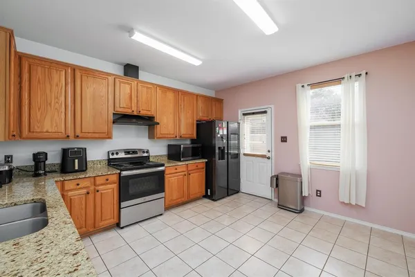 a kitchen with stainless steel appliances granite countertop a stove top oven a sink dishwasher and a refrigerator