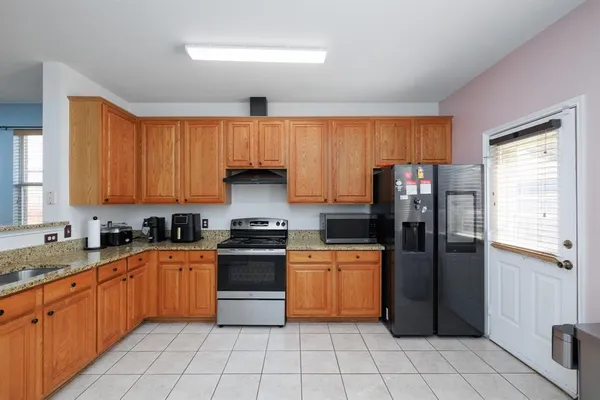a kitchen with stainless steel appliances granite countertop a stove a sink dishwasher and a refrigerator