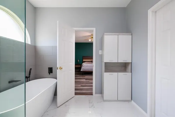 a bathroom with a bathtub and a walk in closet