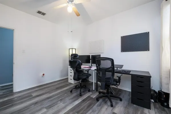 a view of a workspace with furniture and a window