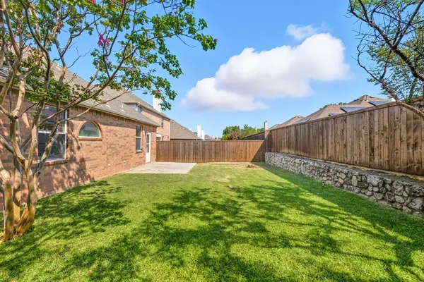a view of backyard with potted plants and wooden fence