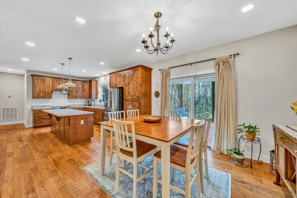 a view of a dining room with furniture a chandelier and wooden floor