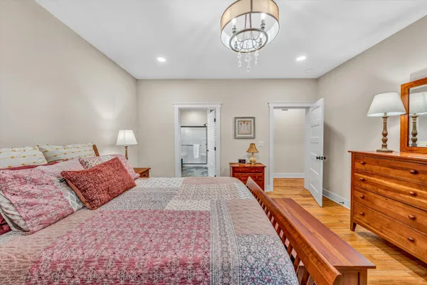 a bedroom with a bed and dresser with mirror