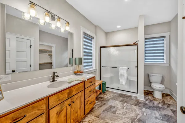 a bathroom with a double vanity sink mirror and toilet