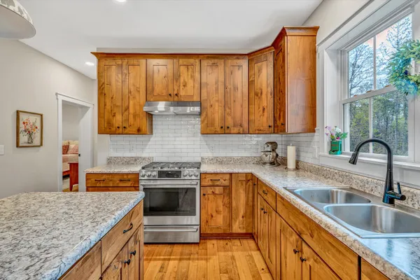 a kitchen with stainless steel appliances granite countertop a sink a stove top oven a counter space and cabinets