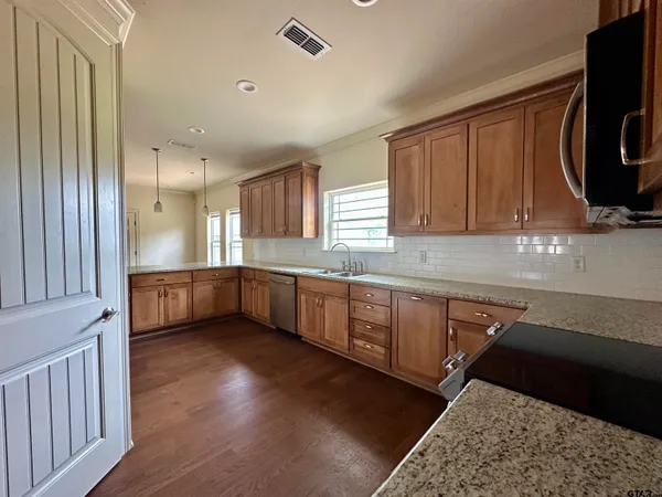 a kitchen with stainless steel appliances sink a stove and cabinets