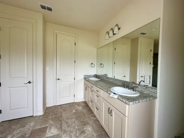 a spacious bathroom with a granite countertop sink and a mirror