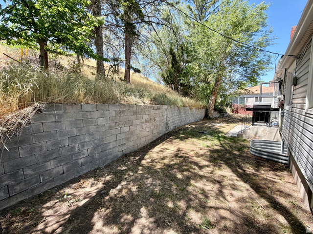 7 Foothill Boulevard Pocatello, ID 83204 - Photo 13 of 13 Expansive backyard featuring a concrete block retaining wall and mature trees