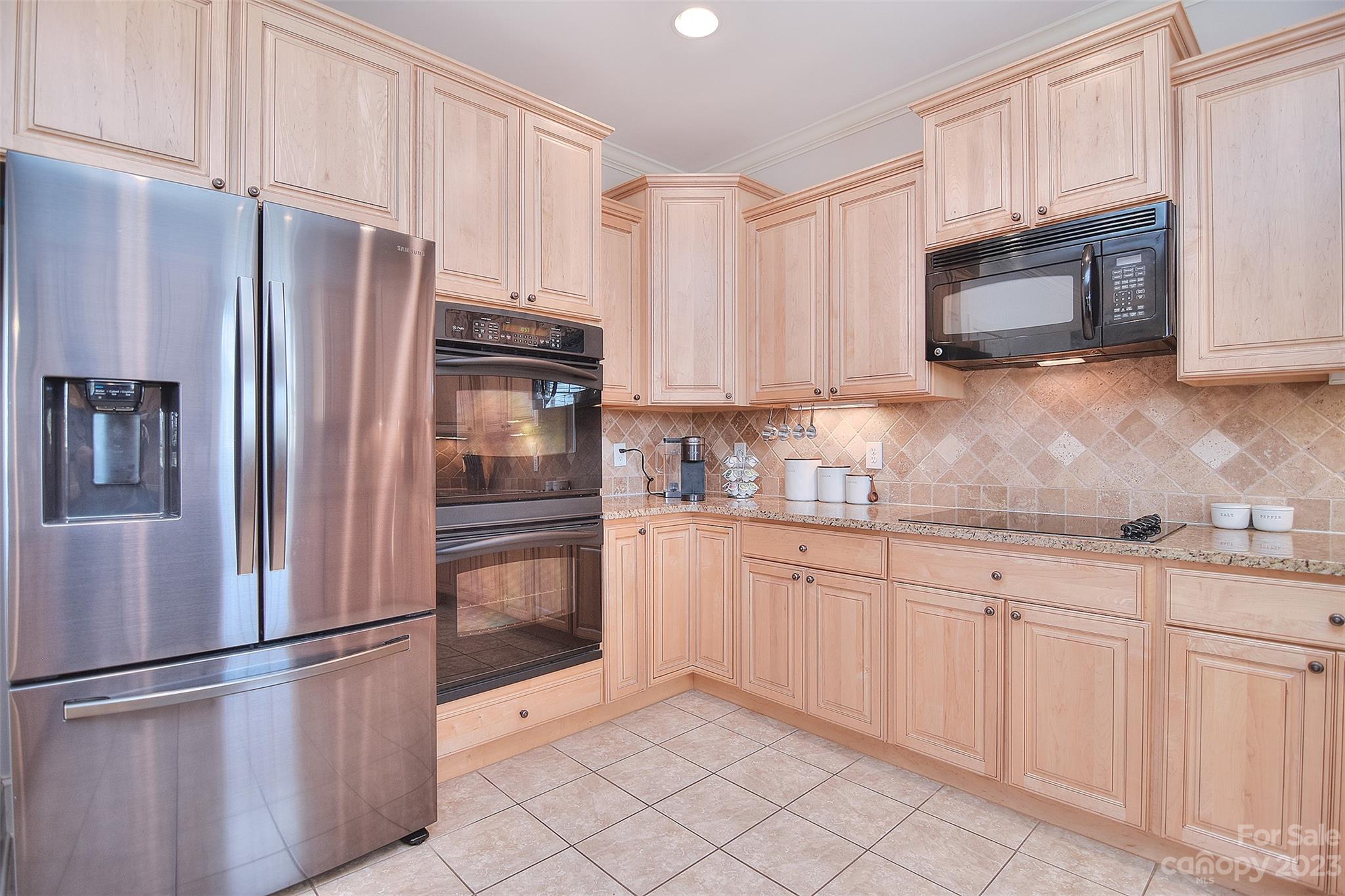 4913 Campobello Drive Monroe, NC 28110 - Photo 16 of 46 a kitchen with granite countertop white cabinets and stainless steel appliances
