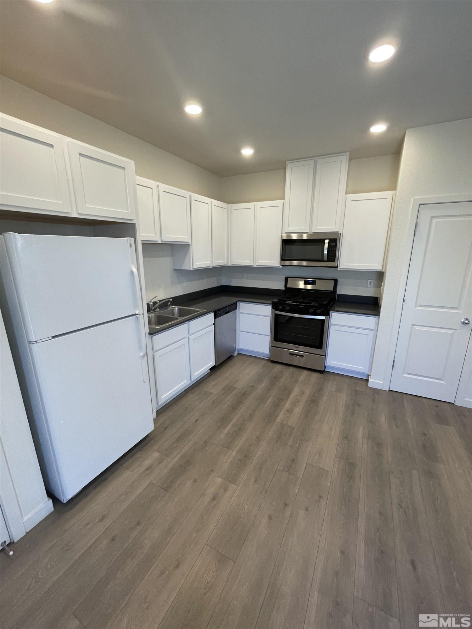 8839 Wolf Moon Drive Reno, NV 89506 - Photo 5 of 15 a kitchen with granite countertop a refrigerator and a stove top oven