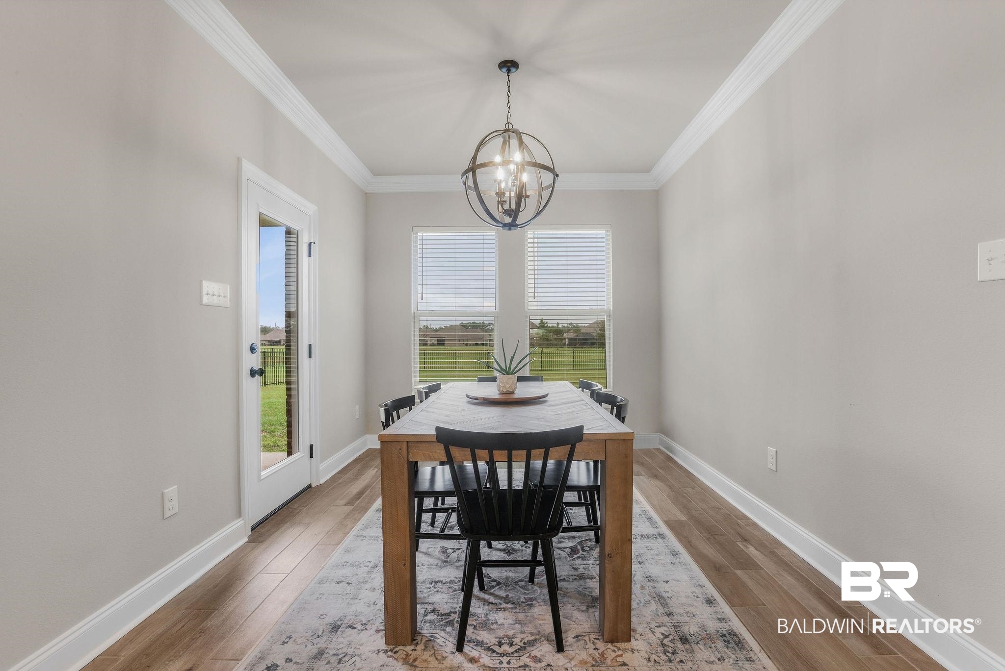 9988 Chipper Lane Foley, AL 36535 - Photo 9 of 26 Dining space featuring ornamental molding, a notable chandelier, and hardwood / wood-style flooring
