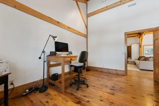 a view of a workspace with furniture and a window