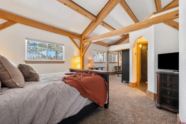 a bedroom with a bed and a television on dresser