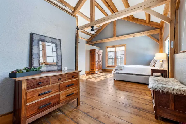 a bedroom with a bed and a mirror on the dresser