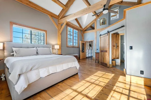 a spacious bedroom with a bed and a chandelier