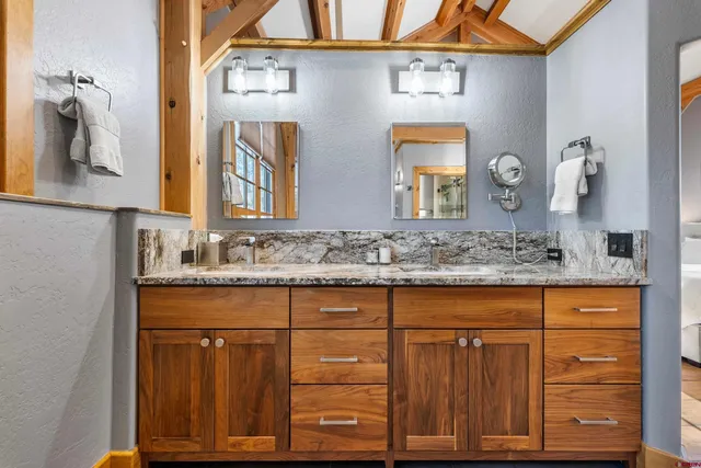 a bathroom with a granite countertop sink and a mirror