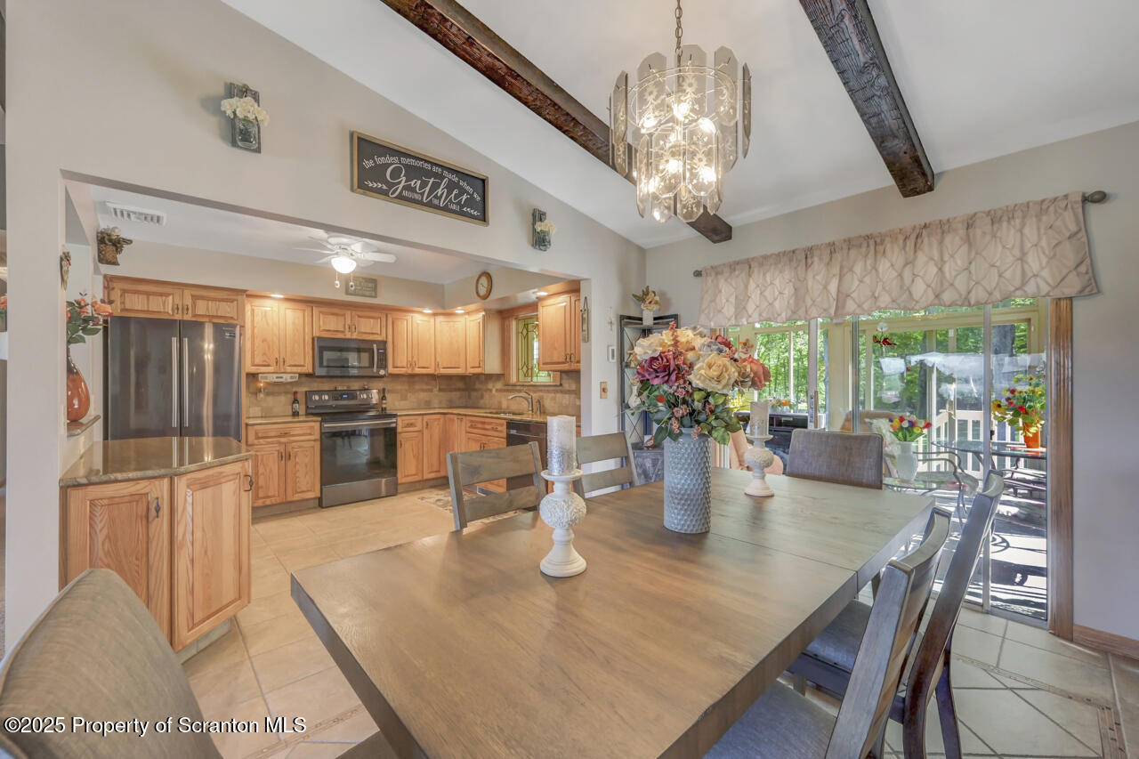 143 Beech Road Moscow, PA 18444 - Photo 20 of 89 a kitchen with stainless steel appliances granite countertop a dining table chairs and chandelier