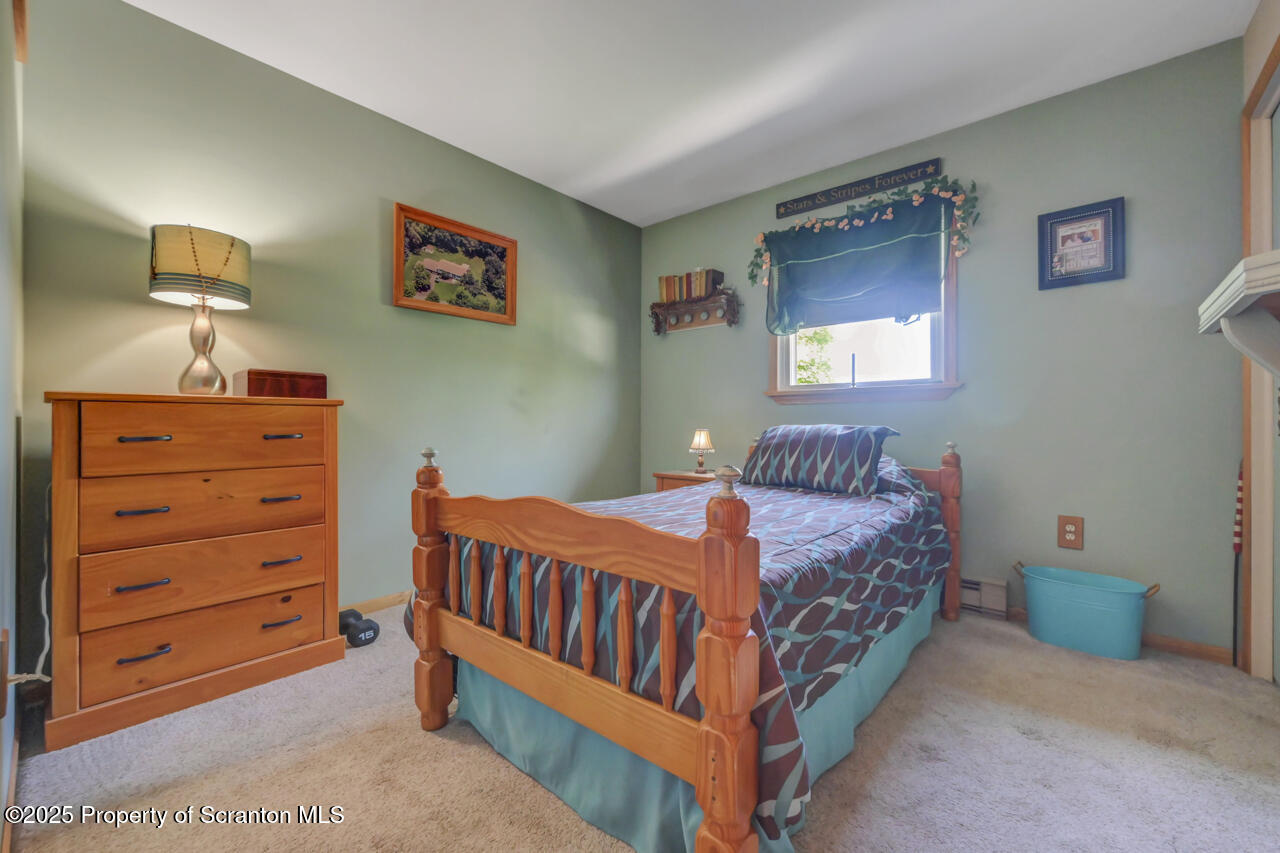 143 Beech Road Moscow, PA 18444 - Photo 46 of 89 a bedroom with a bed and a lamp on dresser
