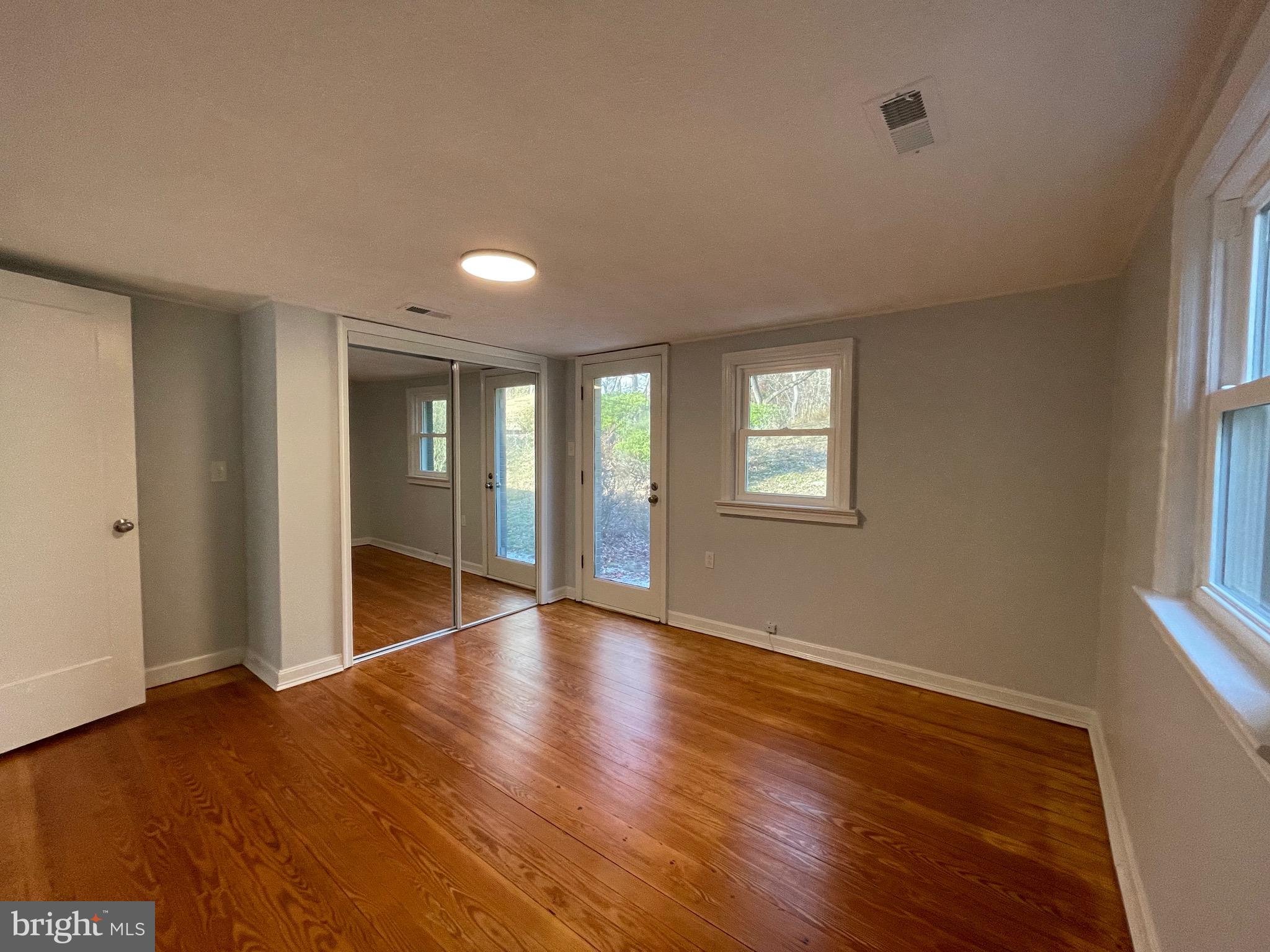 240 Whorton Hollow Road Castleton, VA 22716 - Photo 16 of 37 an empty room with wooden floor and windows