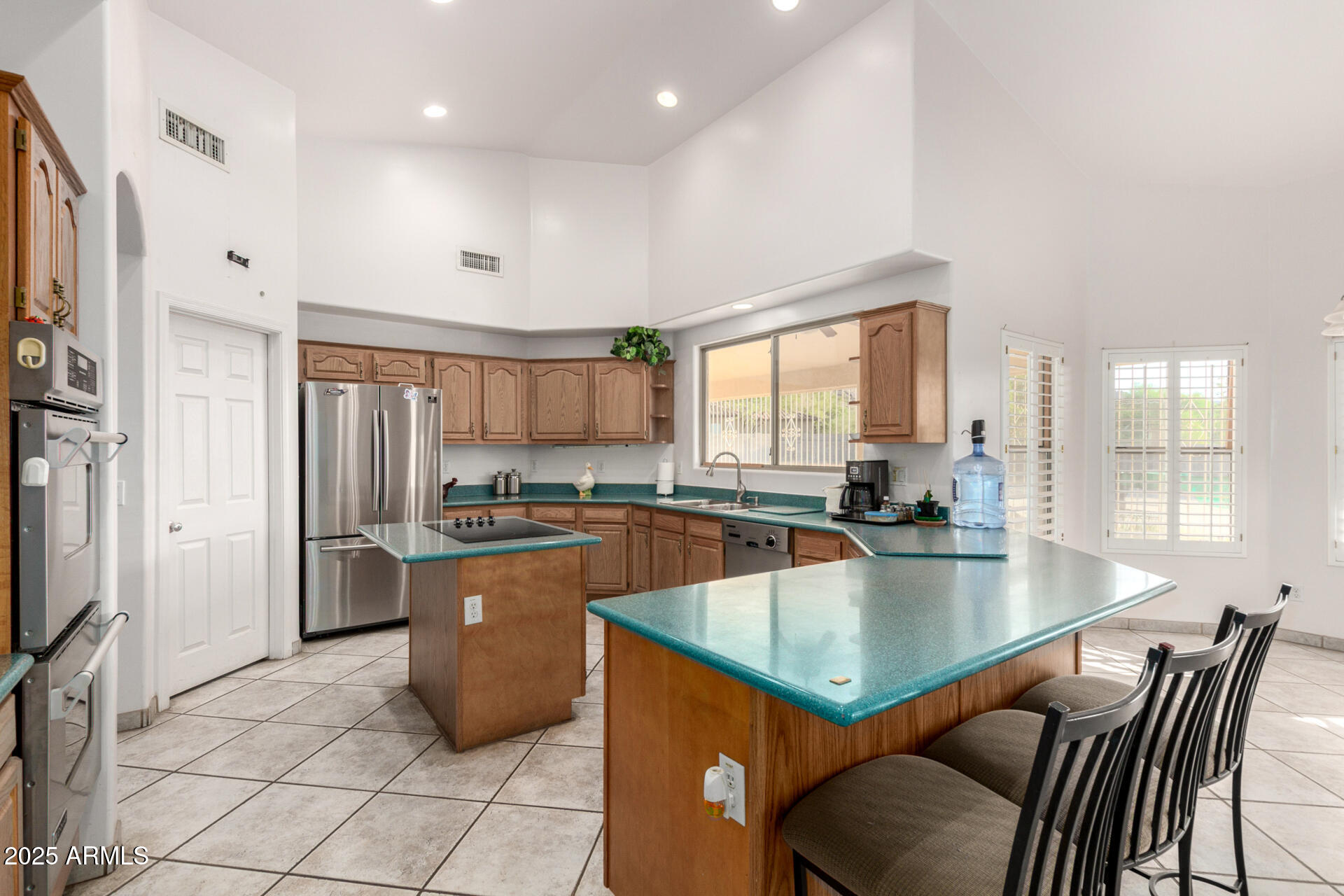 8828 South 16th Street Phoenix, AZ 85042 - Photo 18 of 63 a kitchen with a table chairs refrigerator and cabinets