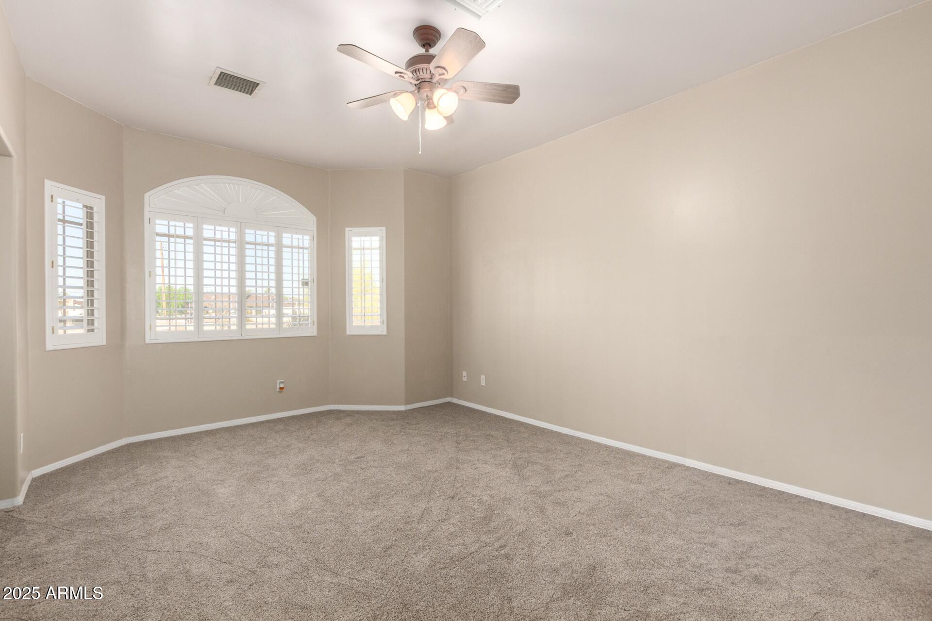8828 South 16th Street Phoenix, AZ 85042 - Photo 30 of 63 an empty room with windows and chandelier fan