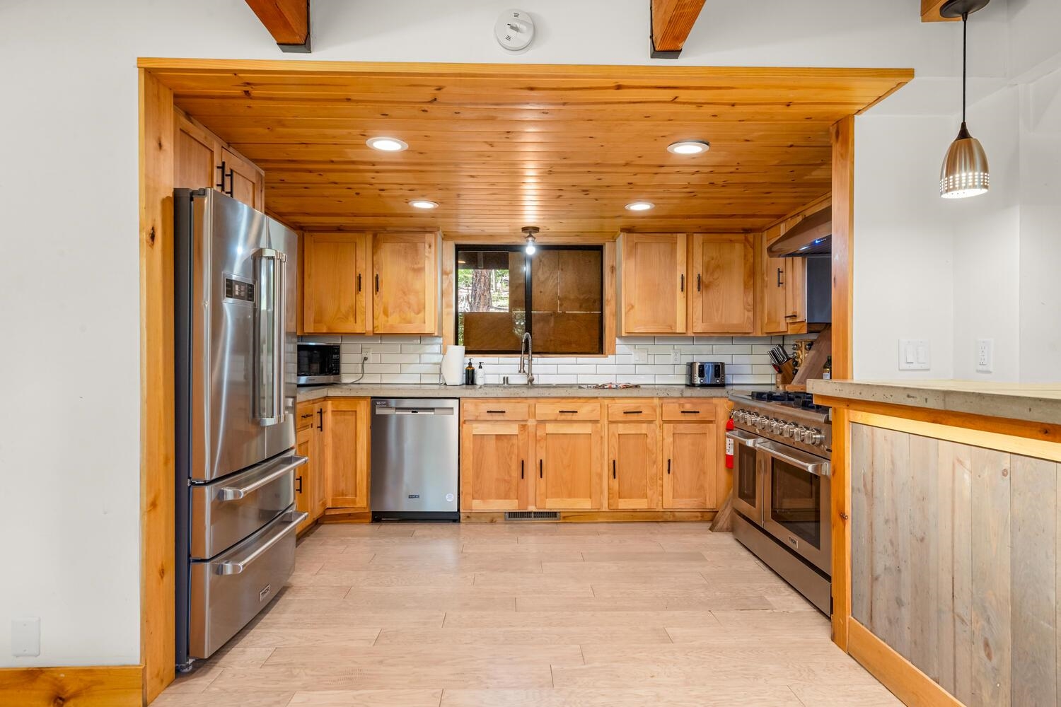 573 Granite Road Carnelian Bay, CA 96140 - Photo 5 of 21 a kitchen with white cabinets and stainless steel appliances