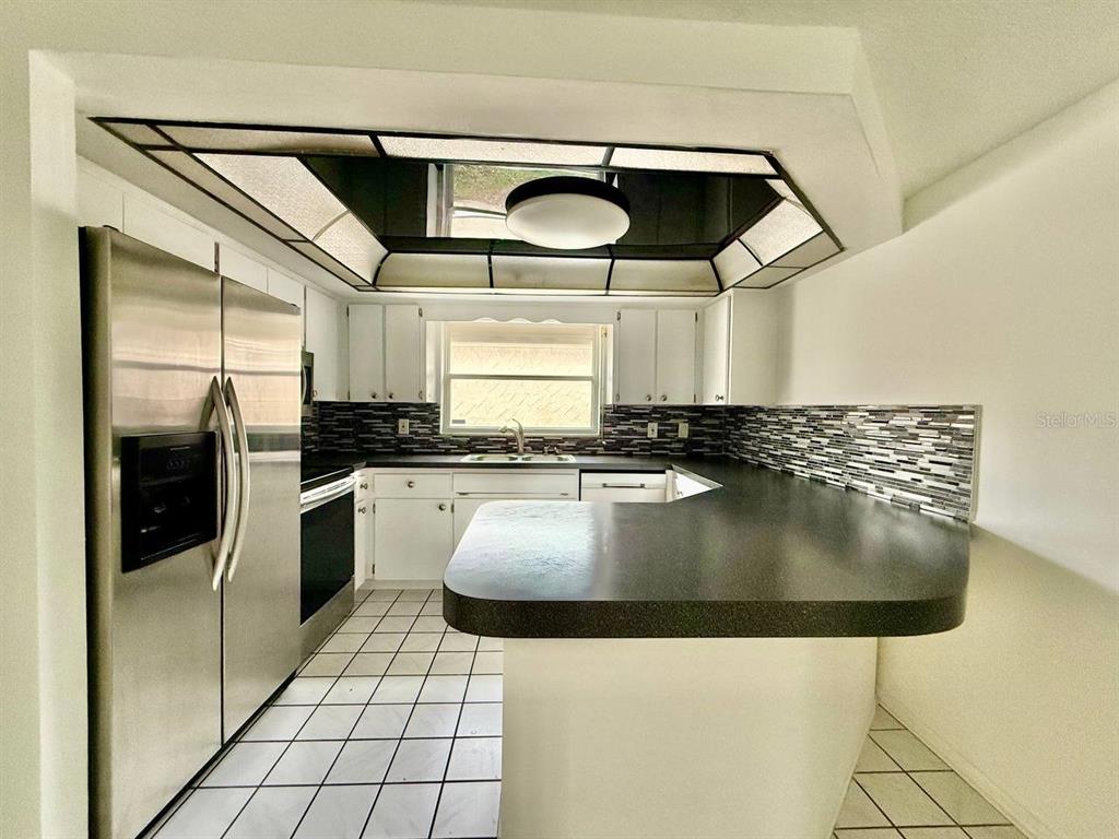 7131 Potomac Drive Port Richey, FL 34668 - Photo 11 of 30 a kitchen with stainless steel appliances granite countertop a sink a stove and cabinets