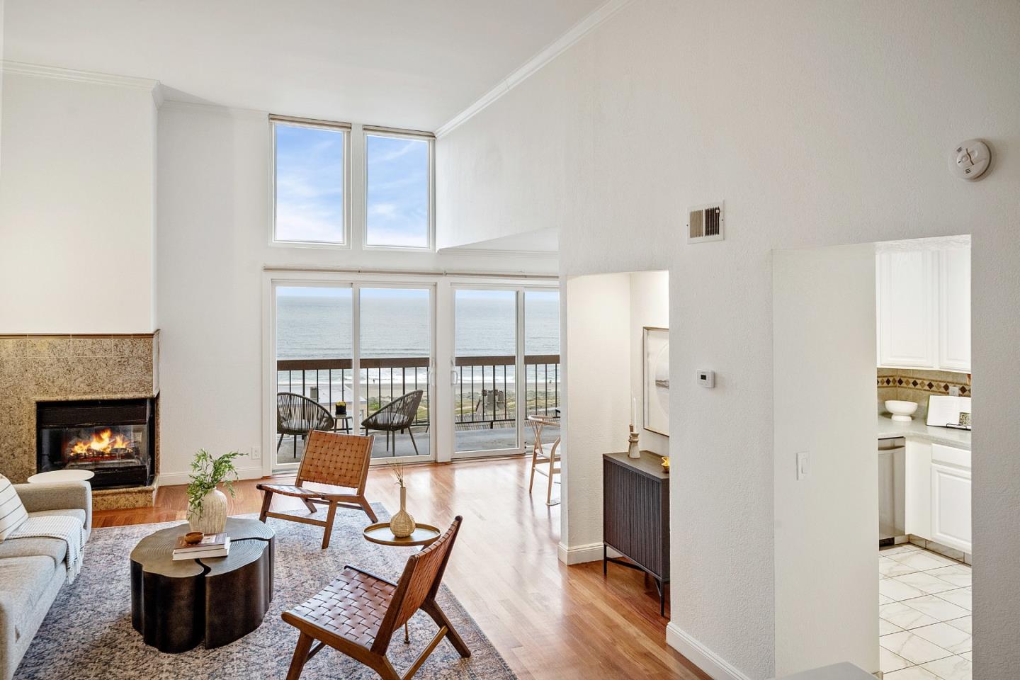 a living room with furniture a fireplace and a floor to ceiling window