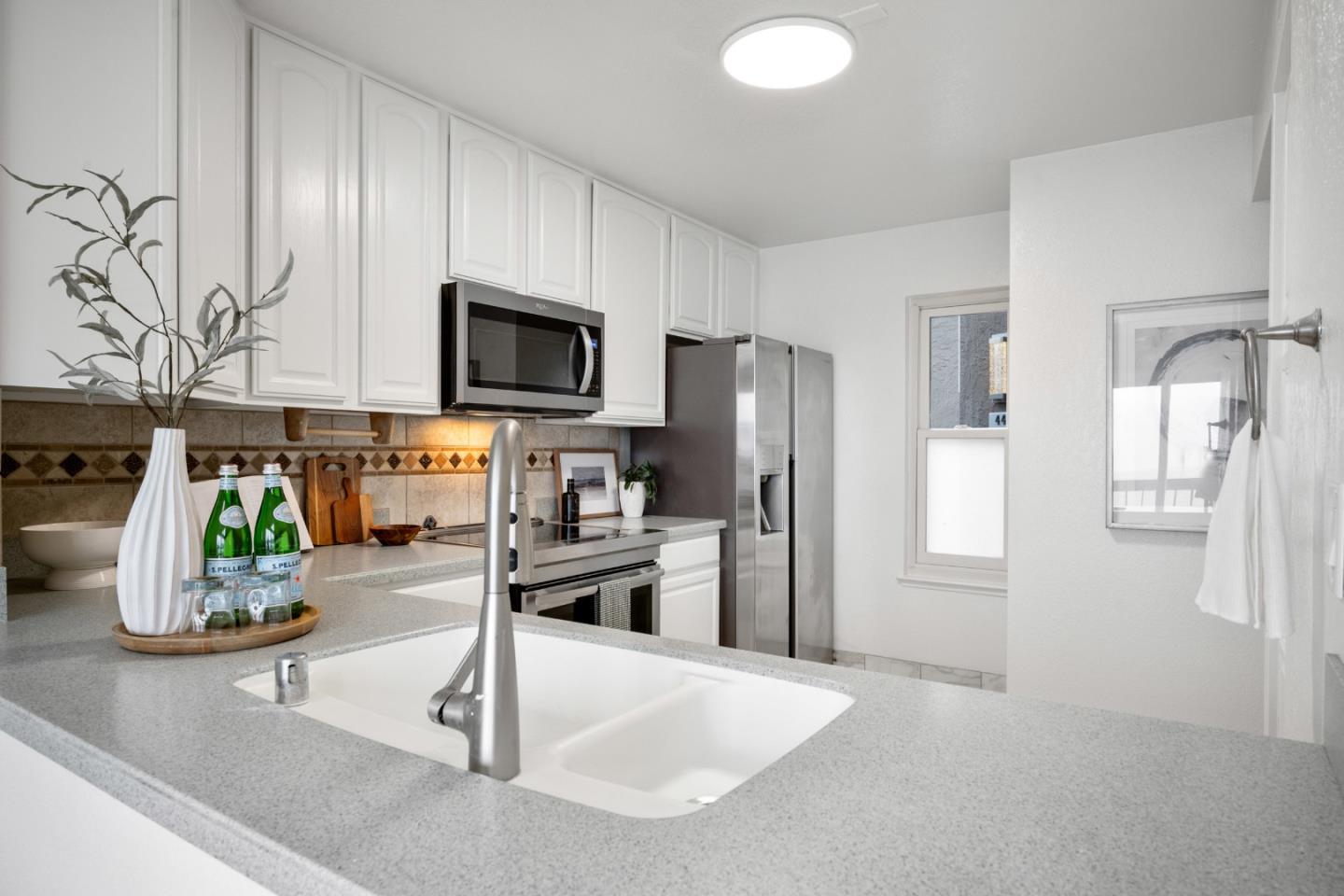 445 Roberts Road Pacifica, CA 94044 - Photo 13 of 40 a kitchen with stainless steel appliances granite countertop a refrigerator a stove and a sink with wooden floor