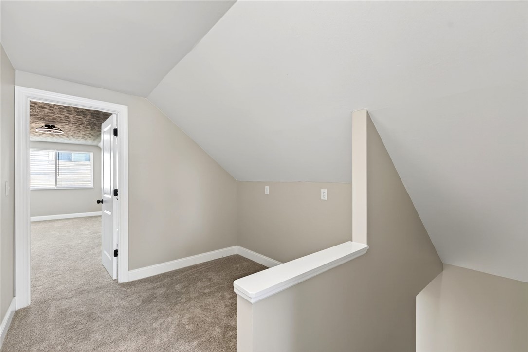 5975 Rosalie Road Dayton, OH 45424 - Photo 21 of 48 An inviting loft space features a sloped ceiling and carpeted flooring, creating a cozy atmosphere.