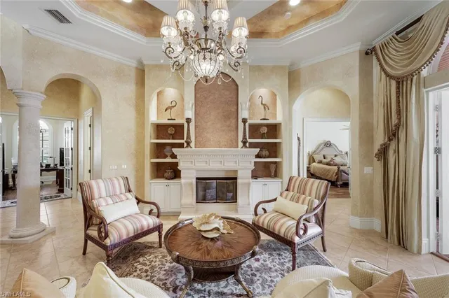 a living room with furniture a fireplace and a chandelier
