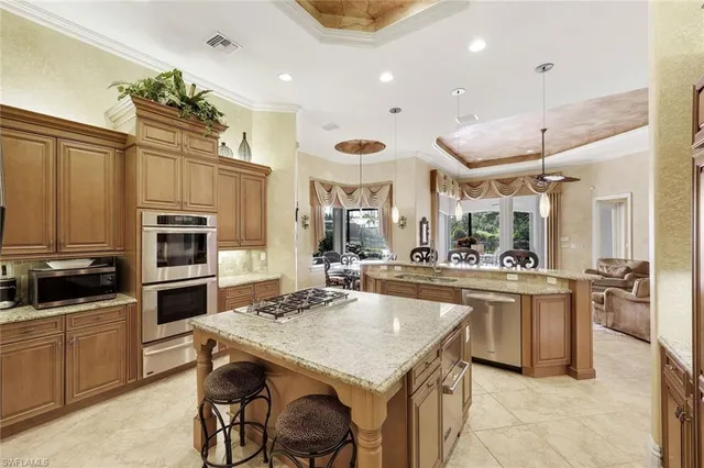 a kitchen with kitchen island a large counter top space appliances and cabinets