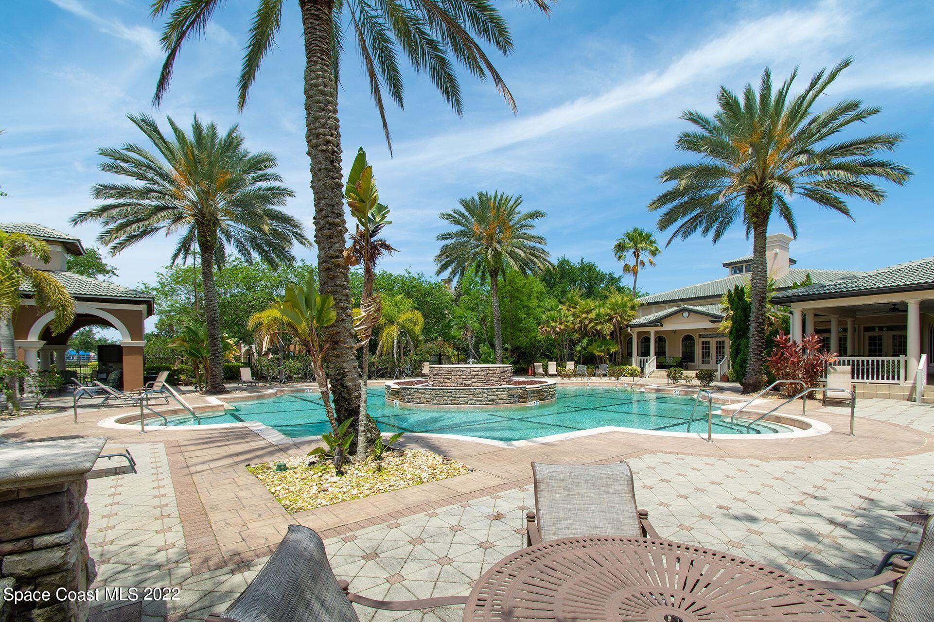 6460 Borasco Drive, Unit 1902 Melbourne, FL 32940 - Photo 28 of 36 a palm tree sitting in front of a house with a yard