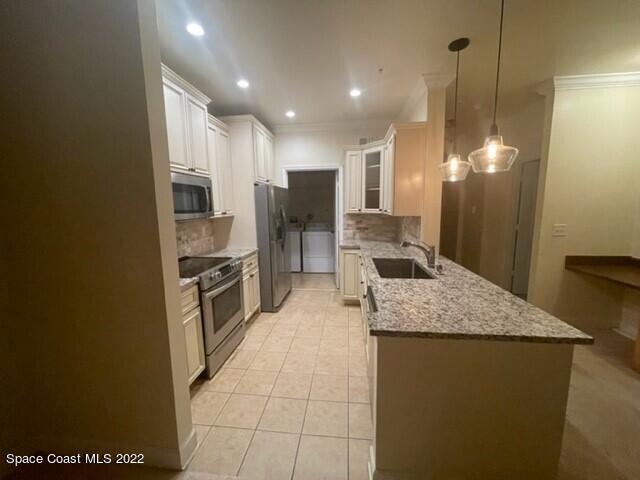 6460 Borasco Drive, Unit 1902 Melbourne, FL 32940 - Photo 3 of 36 a kitchen with kitchen island granite countertop a sink a counter top space appliances and cabinets