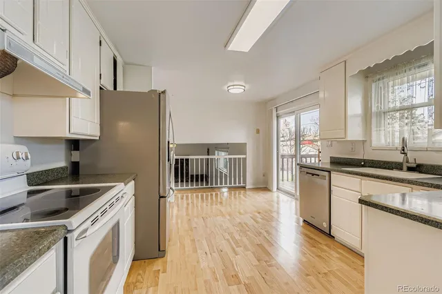 a kitchen with granite countertop a sink stove and refrigerator