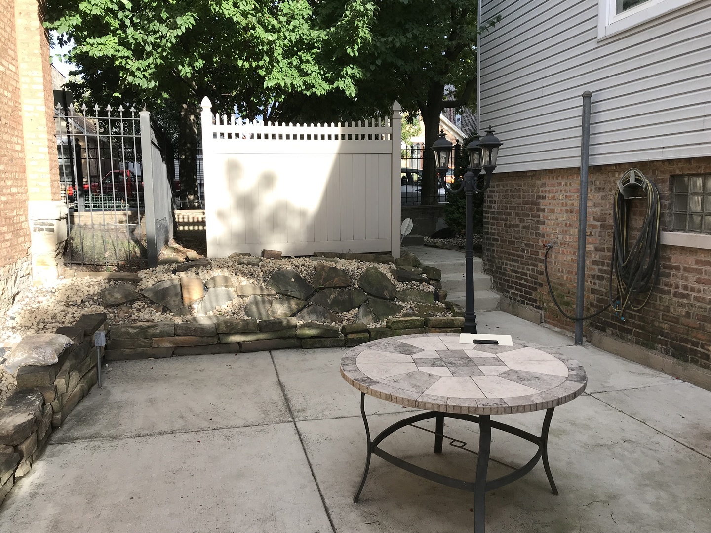3110 South Racine Avenue Chicago, IL 60608 - Photo 18 of 23 a view of a patio with table and chairs with wooden fence and plants