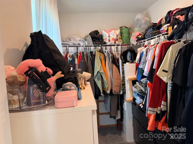 a view of walk in closet with clothes and shoes