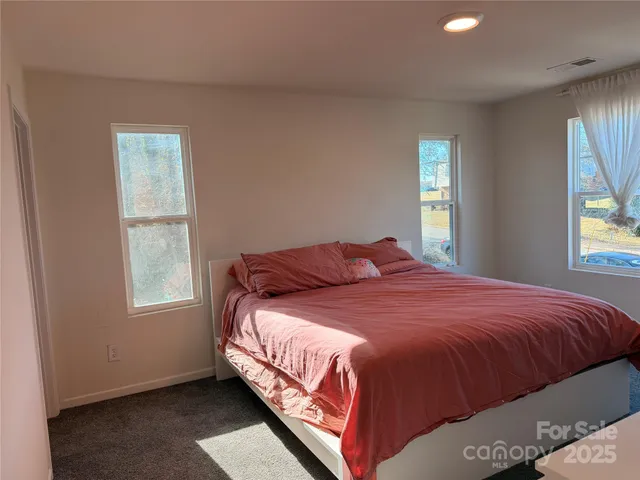 a bed sitting in a bedroom next to a window